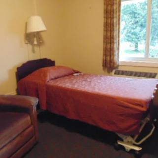 A simple bedroom with a single bed and window view.