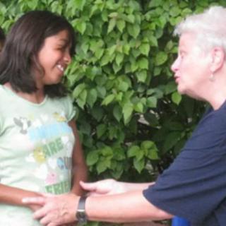 Two people engaging in a friendly conversation outdoors.