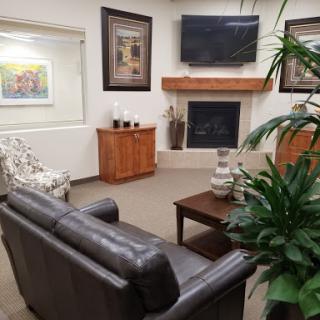 A cozy living room featuring a leather sofa, a coffee table, and decorative artwork on the walls.
