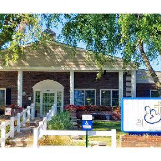 A welcoming entrance to a community center surrounded by lush greenery.