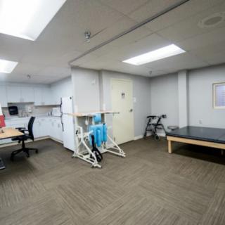 An empty office space with exercise equipment and a desk.
