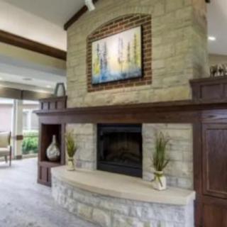 A modern living room featuring a stone fireplace with artwork above it.
