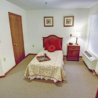 A cozy bedroom with a single bed, nightstand, and decorative elements.