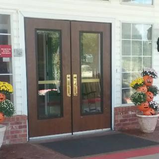A welcoming entrance featuring double glass doors and colorful flower arrangements.