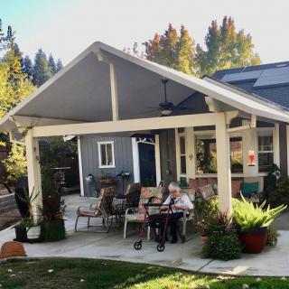 A cozy outdoor patio area with seating and surrounded by greenery.