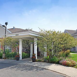 A welcoming entrance with a covered driveway and landscaped surroundings.