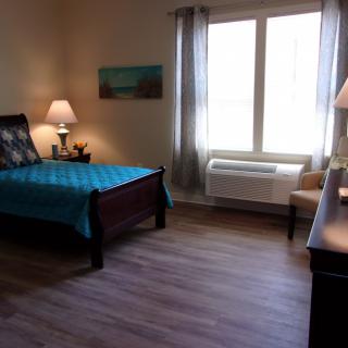 A cozy bedroom with a large window, comfortable bed, and tasteful decor.