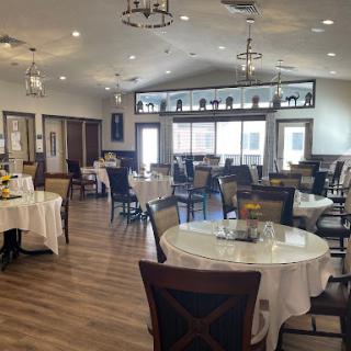 A spacious and elegantly designed restaurant interior with well-set tables ready for dining.