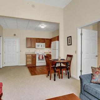 A cozy apartment featuring an open-plan living room with a kitchen and dining area.