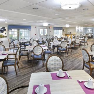 A spacious dining room with neatly arranged tables and chairs, prepared for dining.
