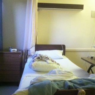 A hospital room with an unoccupied bed and medical equipment.