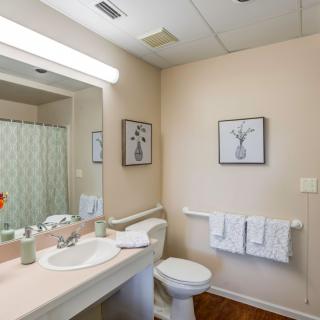 A clean and neatly organized bathroom with modern fixtures and simple decor.