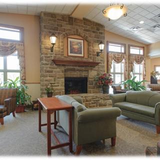 A cozy lobby with a stone fireplace, comfortable seating, and large windows letting in natural light.
