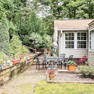 A cozy patio area with outdoor seating, surrounded by lush greenery and potted plants.