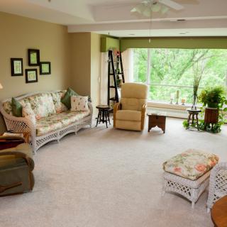 A cozy living room with comfortable furniture and a large window overlooking greenery.
