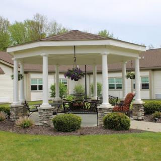 A beautifully designed gazebo surrounded by lush greenery, perfect for outdoor gatherings.