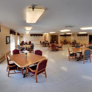 A spacious dining area with tables and chairs set up for communal activities.