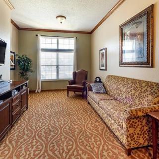 A traditionally designed living room with patterned carpet, a sofa, and a television.