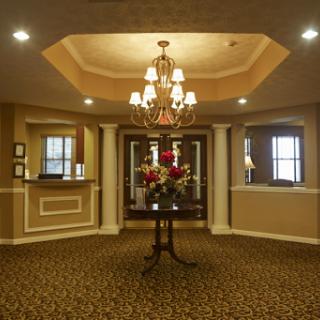 An elegant lobby featuring a chandelier and floral decor.