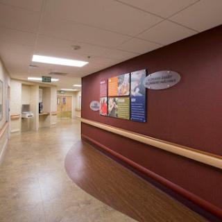 A well-lit hospital hallway featuring colorful informational posters on the wall.