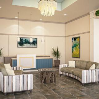 A modern lobby with stylish sofas, a chandelier, and vibrant artwork.