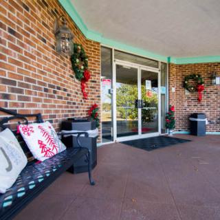 A festive entrance adorned with holiday wreaths and a welcoming bench.