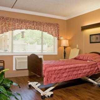 A hospital room with a single bed, window, and comfortable furnishings.