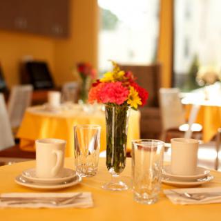 A beautifully arranged dining table with vibrant flowers and elegant glassware.