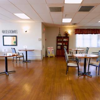 A spacious and inviting dining area with tables and chairs, designed for comfort and community gatherings.