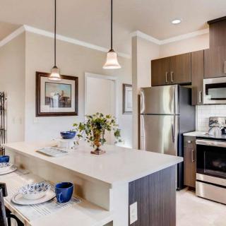 A modern kitchen with stainless steel appliances and an island counter.