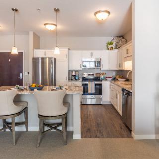 A modern apartment kitchen with stainless steel appliances and a cozy dining area.