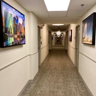 A well-lit hallway with artwork displayed on the walls.