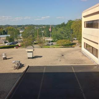 A view from a building showing a clear sky and surrounding landscape.