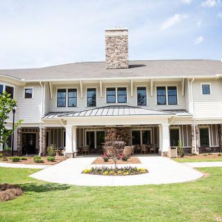A luxurious two-story house with a well-maintained lawn and modern architectural design.