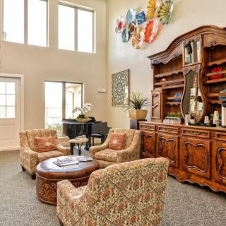 A spacious living room with elegant furniture and decorative elements.