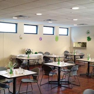 A decorated indoor event space with tables and chairs set up for a gathering.