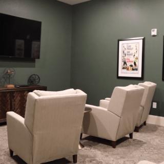 A cozy home theater setup with recliner chairs and a large TV.
