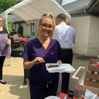 A healthcare staff member enjoying a meal at an outdoor event.