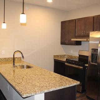 A modern kitchen with granite countertops and stainless steel appliances.