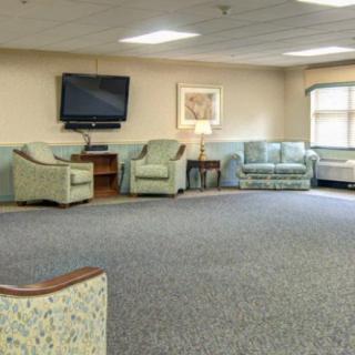 A spacious waiting room with comfortable seating and a wall-mounted television.