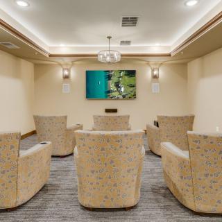 A conference room with comfortable seating and a television screen.