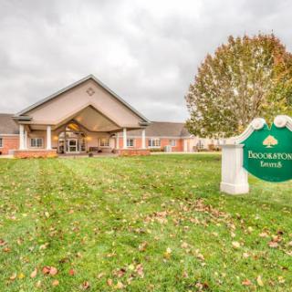 A welcoming residential building with well-maintained landscaping and a sign visible in the foreground.