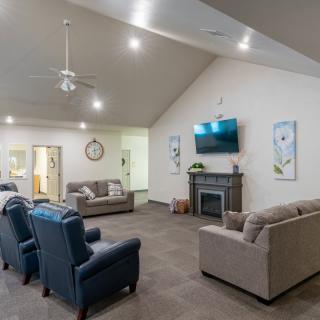 A spacious living room featuring comfortable seating, a mounted television, and a modern fireplace.
