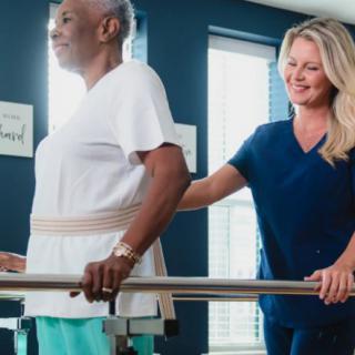 A healthcare professional assists a patient during a physical therapy session.