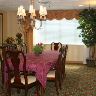 A traditional dining room with a set table and chandelier.