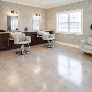 A modern and spacious salon interior featuring elegant chairs and ample natural light.