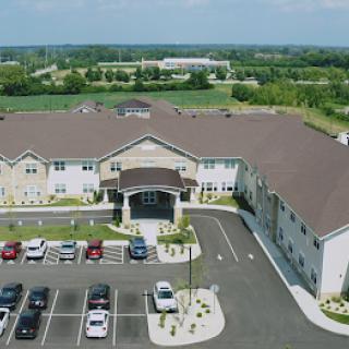 Aerial view of a modern residential building with a spacious parking lot.