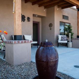 A cozy outdoor patio featuring a water fountain and comfortable seating.