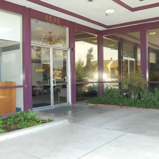 Entrance to a building with glass doors and surrounding plants.