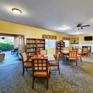 A cozy indoor library with bookshelves, tables, and chairs for reading and relaxation.
